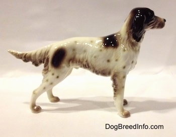 The right side of a figurine of a white with brown English Setter in a standing pose. The figurine has brown spots all over its body.
