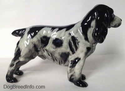 The right side of a black and white figurine of an English Springer Spaniel. The figurine has small black paws.