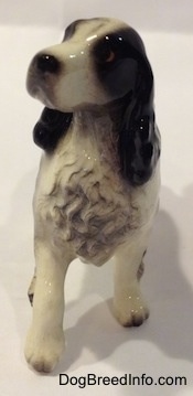 A black with white English Springer Spaniel ceramic figurine. The chest hair of the figurine is very detailed.