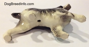 The underside of a black with white English Springer Spanirl ceramic figurine. There is a hole in the underside of the figurine.