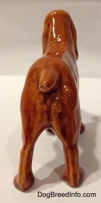 The back of a brown Field Spaniel ceramic figurine. It is hard to differentiate the difference between the ears of the figurine from the head.