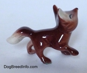 The right side of a Baby Fox figurine that is standing. Its front right paw is lifted into the air.