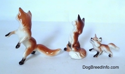The left side of a three Fox figurines. All of the figurines have have black paws.