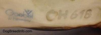 Close up - The underside of a German Shepherd figurine with the blue stamp of Goebel W.Germany and next to it is the engraving number 'CH618'.