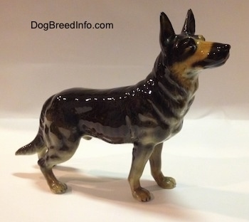 The right side of a black with tan German Shepherd figurine that has fine hair details along its body.