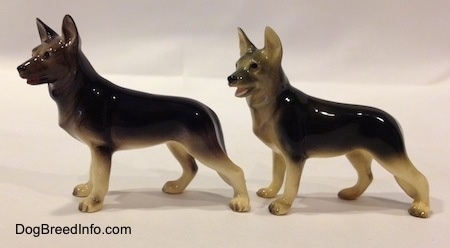 The left side of two black with tan standing German Shepherd figurines.