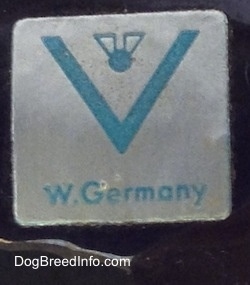 Close up - On the underside of a figurine there is a sliver and blue sticker that has a full bee inside the V logo and under that are the words - W.Germany.