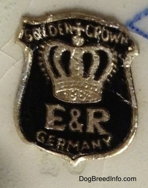 Close up - A Golden Crown E&R Germany Sticker on the bottom of a figurine.