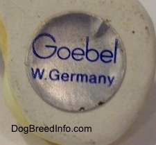 Close up - The underside of a figurines leg and on it is the sticker of Goebel W.Germany.
