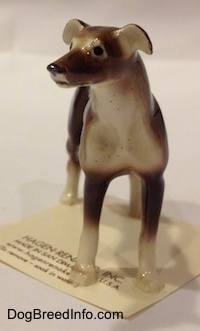 A brown with white Greyhound figurine. The figurine has medium sized ears that are out a litte.