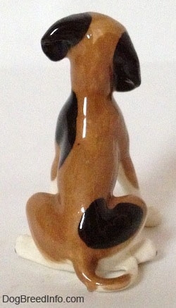 A brown and white with black vintage Hound dog figurines back. There are two spots on along the back and side of the figurine.