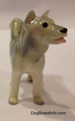 The front of a grey and white Husky figurine. The figurine has short ears that are grey.