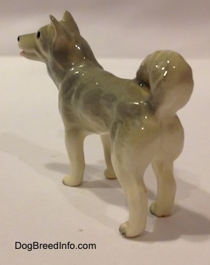The back left side of a grey and white Husky figurine. The figurine is very glossy.
