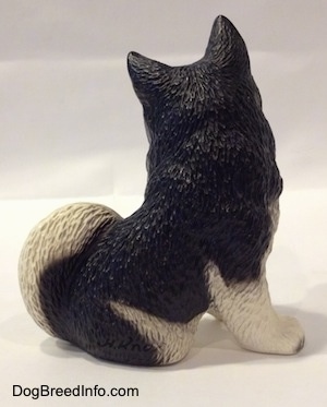 The right side of a black and white Husky figurine. THe figurine has fine hair details.