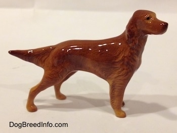 The right side of a brown Irish Setter figurine. The figurine has long legs and a hairy body.