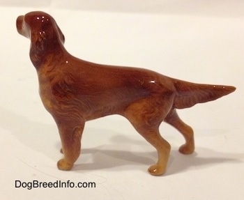 The left side of a brown Irish Setter figurine that is glossy. The figurine has brown ears that are hard to differentiate from its body.
