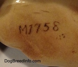 Close up - The underside of a ceramic Irish Setter figurine. On the underside is the letter/number combination - M1758 - that is stamped on it.
