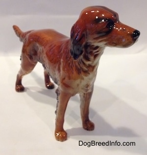 The front right side of a Irish Setter figurine that is brown and black. The figurine has very fine hair details.