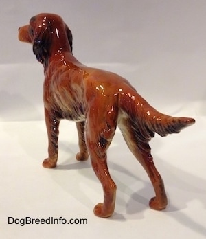 The back left side of a figurine of an Irish Setter. The figurine has hair details at the bottom of its long body and the back of its long legs.