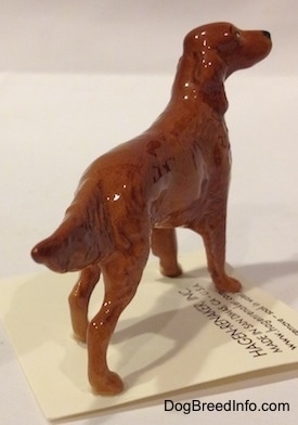The back right side of a brown Irish Setter figurine that is looking up and to the right.