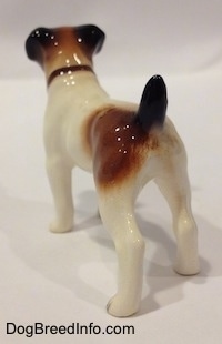 The back left side of a Jack Russell Terrier figurine. The ears and the tail of the figurine are black.