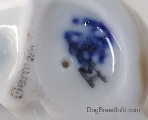 Close up - The underside of a Jack Russell Terrier figurine that has a smudged Goebel full bee logo inked on it and above is a stamp the reads Germany.