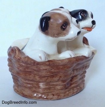 The right side of three Jack Russell Terriers that are in a wicker basket figurine. The figurines have short black ears.