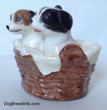 The left side of three Jack Russell Terriers that are in a wicker basket figurine. The figurines have there paws on the side of a wicker basket.