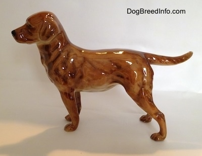 The left side of brown Labrador Retriever figurine. The figurine is very glossy.