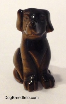 A Labrador Retriever figurine that is carved out of stone. It has a glossy nose.