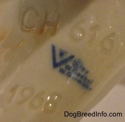 Close up - The underside of a yellow Labrador Retriever with the Goebel trademark 4 logo on it. Numbers and letters are engraved on the underside of the figurine.