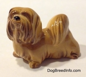 The front left side of a Lhasa Apso figurine. The figurine has fine hair details.