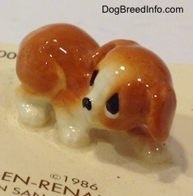 The right side of a figurine of an orange and white puppy figurine.