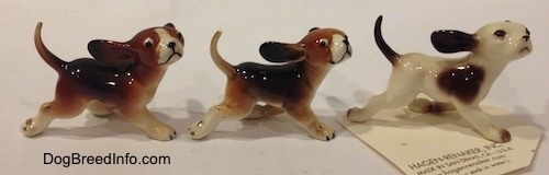 The right side of three Running Dog figurines of different color variations.