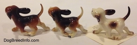 The left side of three running dog figurines in different color variations.
