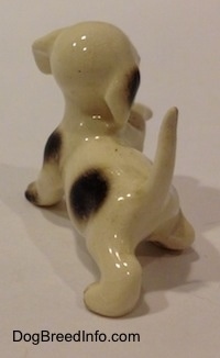 The back left side of a brown spotted Hound dog figurine. The figurine has a glossy head and body.