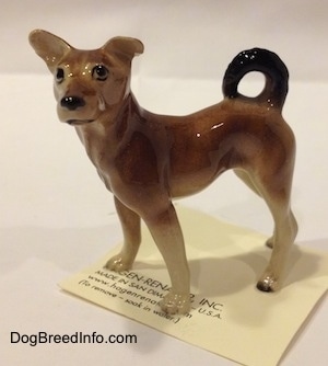 The left side of a figurine of a mixed breed dog.