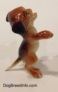 The right side of a dog standing on its hind legs figurine that is in a begging pose. Its front paws are in the air.