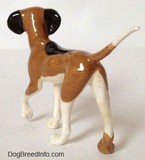 The back left side of a Papa Dog figurine that is tri-color. The figurine has black ears.