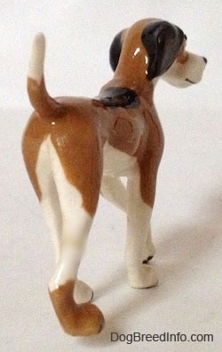 The back right side of a figurine of a Papa Dog. The figurine has a long body.