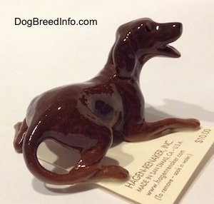 The back right side of a brown playful dog figurine. The figurines ears are hard to differentiate from its head.