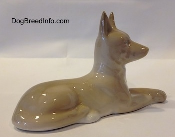 The back right side of a figurine of a Pharoah Hound. The figurine has a long body and legs.