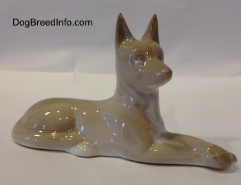 A porcelain figurine of a Pharoah Hound. The figurine is very glossy.