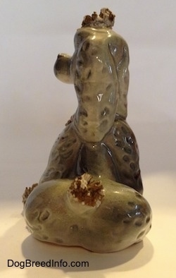 The back of a figurine of a ceramic spaghetti Poodle. The ears of the figurine are hard to differentiate from its head.