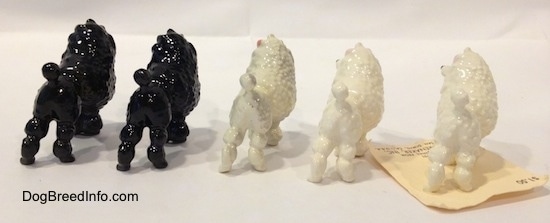 The back right side of five different color variations of a Poodle with a bow in its hair figurine. The figurine has a short tail with a larg poof at the end.