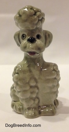 A gray Poodle sitting figurine. The figurine has its mouth open.