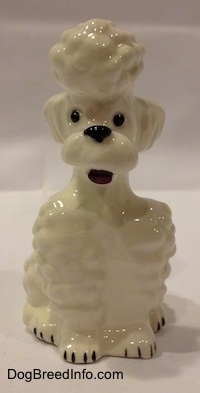 A white Poodle in a sitting pose figurine. The figurine has its mouth open.