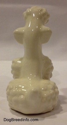 The back of a white Poodle figurine. The figurine has a small tail.
