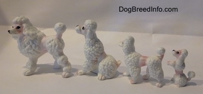 The left side of a bone china family of Poodle figurines. The ears are hard to differentiate from the body of the figurines.