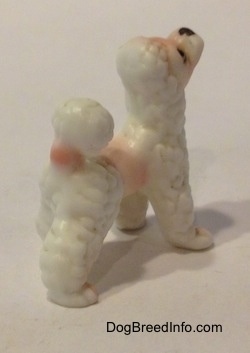 The back right side of a bone china Poodle puppy figurine thas a short poofy tail.
